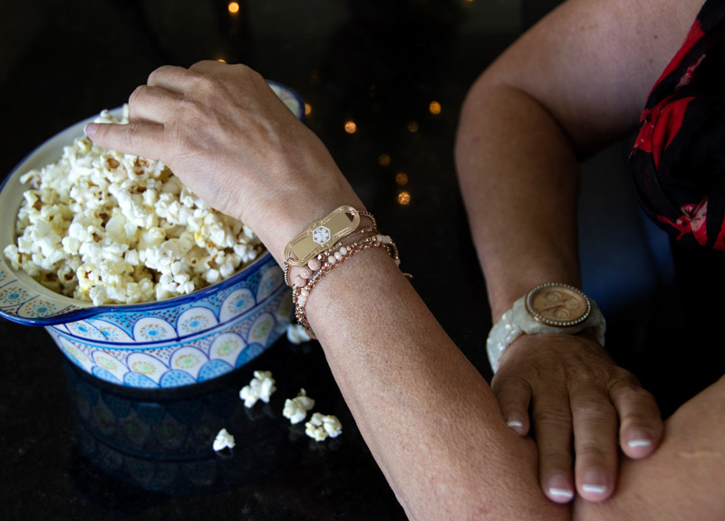 How To Help Someone With Alzheimer’s - Woman eating popcorn with Medical ID